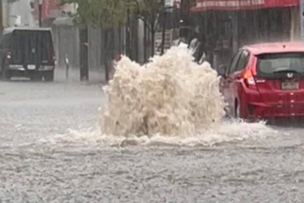 Photo: A car drives in a flooded street after strong downpours in Staten Island, New York