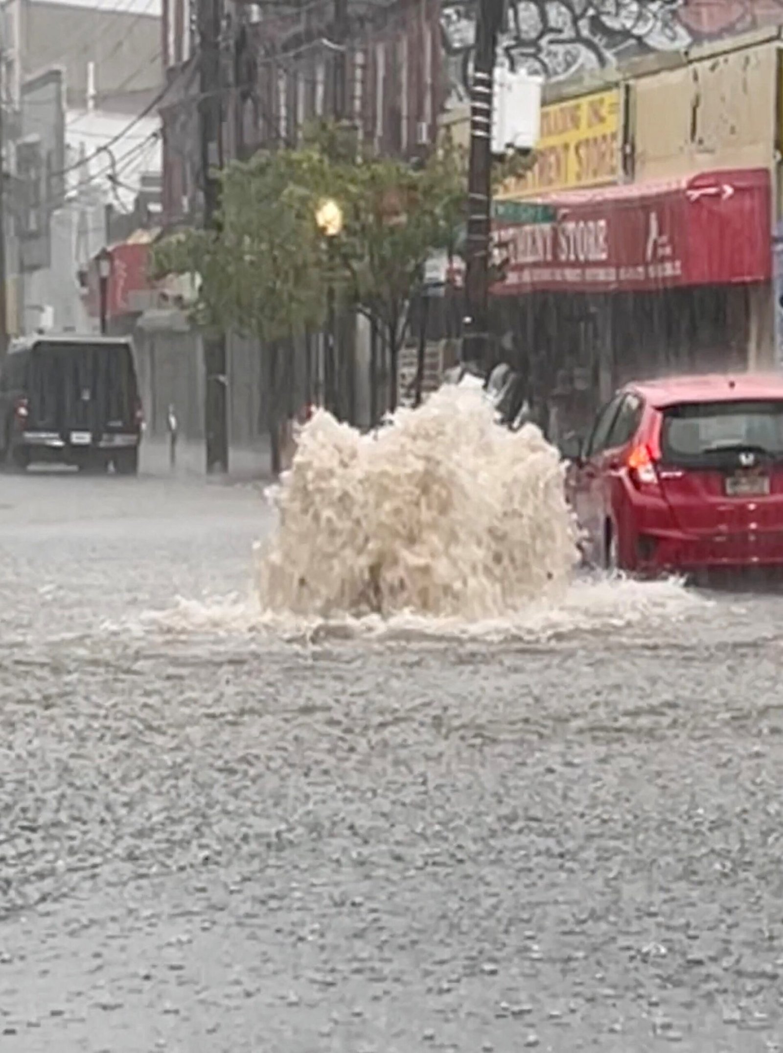 Photo: A car drives in a flooded street after strong downpours in Staten Island, New York
